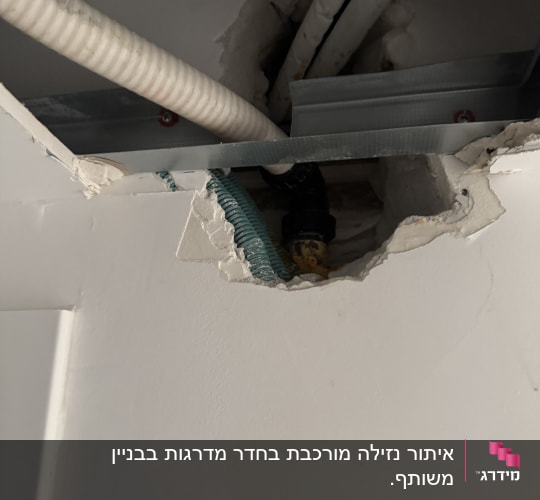 תמונה של צינורות בקיר עם חור בתקרה